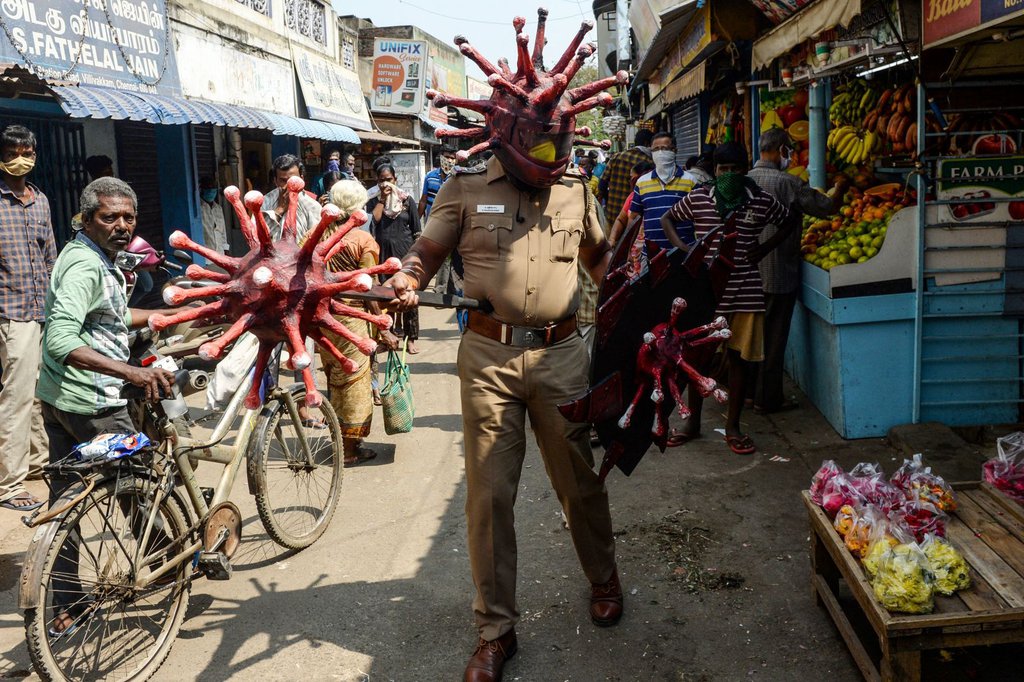 A police officer wearing a coronavirus-themed outfit walks in a market in Chennai, India, to raise awareness about social distancing.Arun Sankar-AFP-Getty Images.jpg