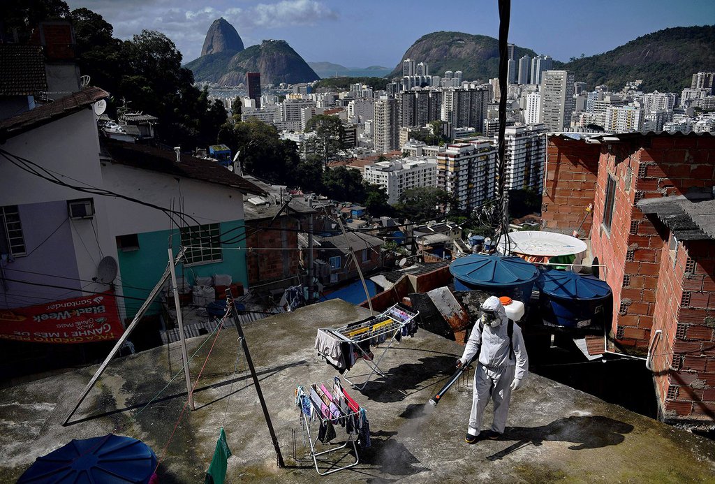A volunteer disinfects a rooftop area in Rio de Janeiro on August 1.Carl De Souza-AFP-Getty Images.jpg