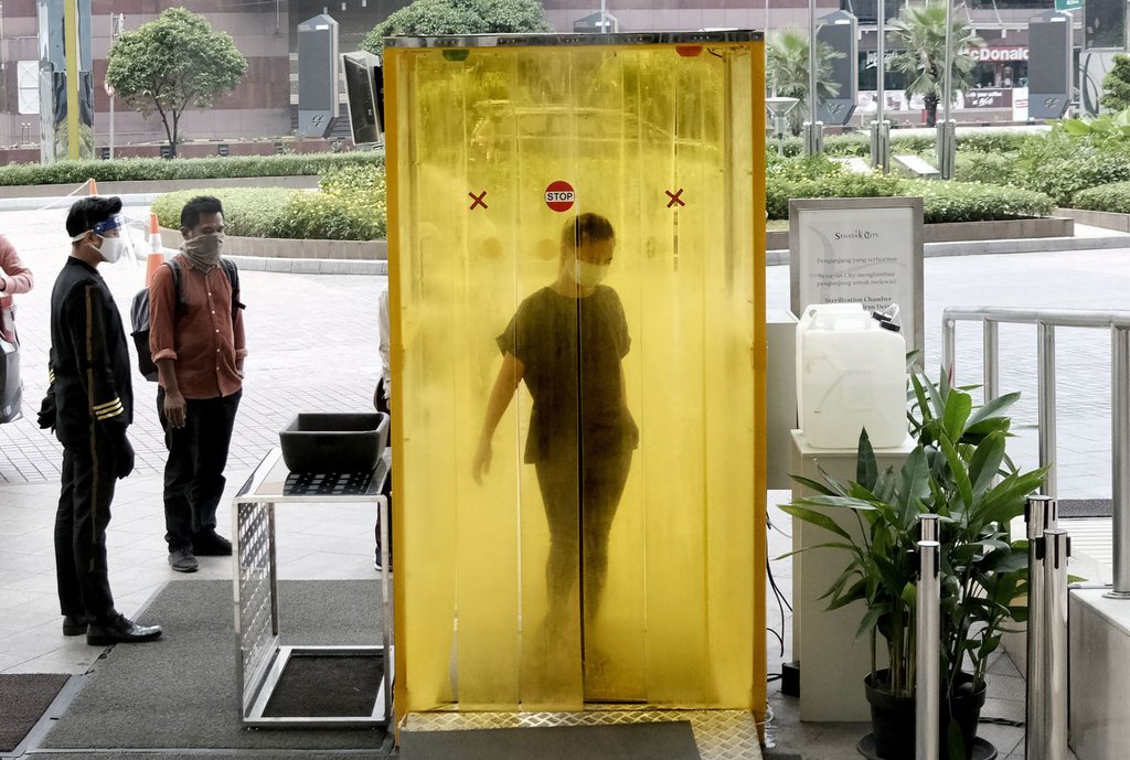 A woman is sprayed with disinfectant before entering a shopping mall in Jakarta, Indonesia, on June 9.Dita Alangkara-AP.jpg