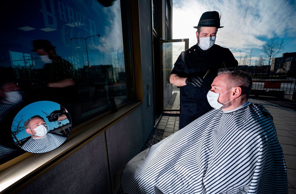 Abed Khankan cuts a customer's hair outdoors in Malmo, Sweden, on April 17.Johan Nilsson-TT News Agency-AFP-Getty Images.jpg