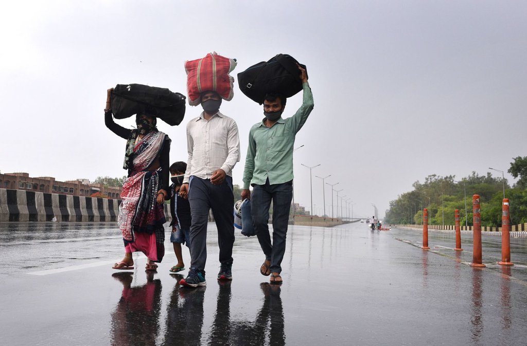 Migrant workers in New Delhi walk toward the Sarai Kale Khan Bus Terminus on May 3 after learning that the government was preparing to send migrant workers back to their home states during the lockdown..jpg
