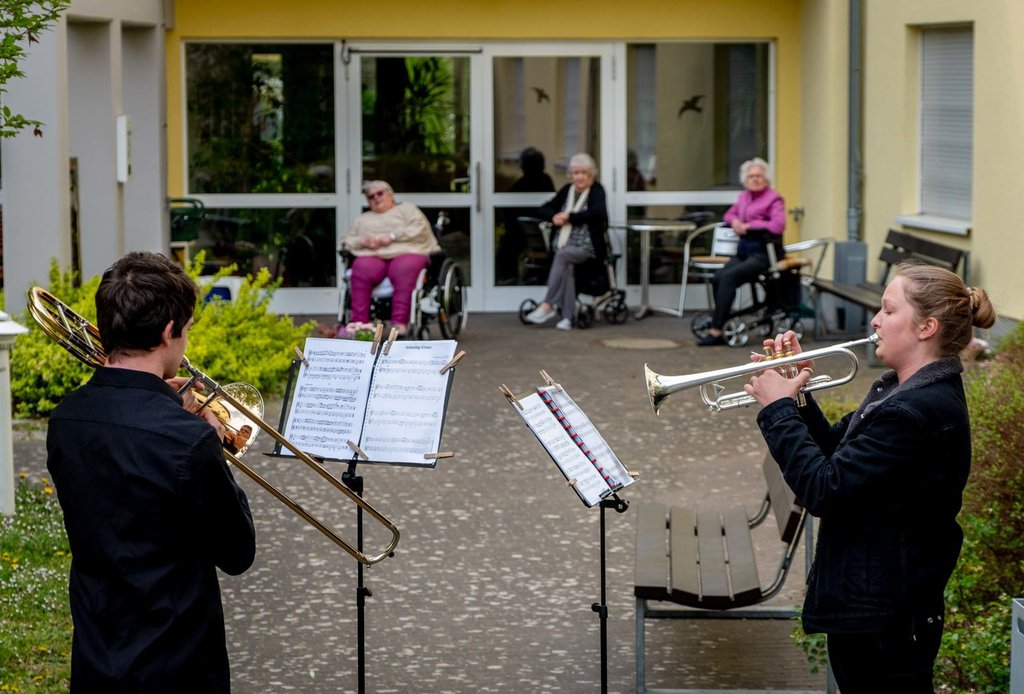 Musicians play their instruments for a retirement home in Karben, Germany, on April 13.Michael Probst-AP.jpg
