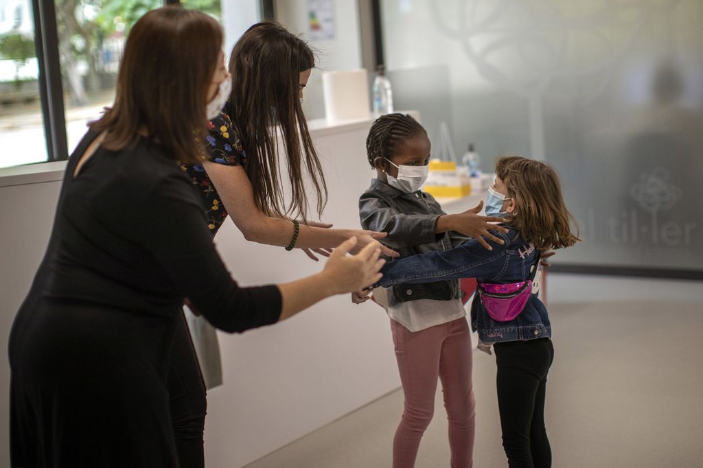 Teachers in Barcelona, Spain, try to prevent a hug between 6-year-olds Wendy Otin and Oumou Salam Niang as they meet on the first day of school following a lockdown.Emilio Morenatti-AP.jpg