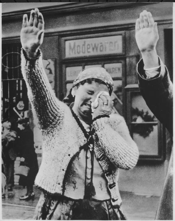 A Sudeten woman from the area that is now the Czech Republic salutes the conquering German forces while crying at the fall of her people to the Nazis, circa 1942-1945..jpg