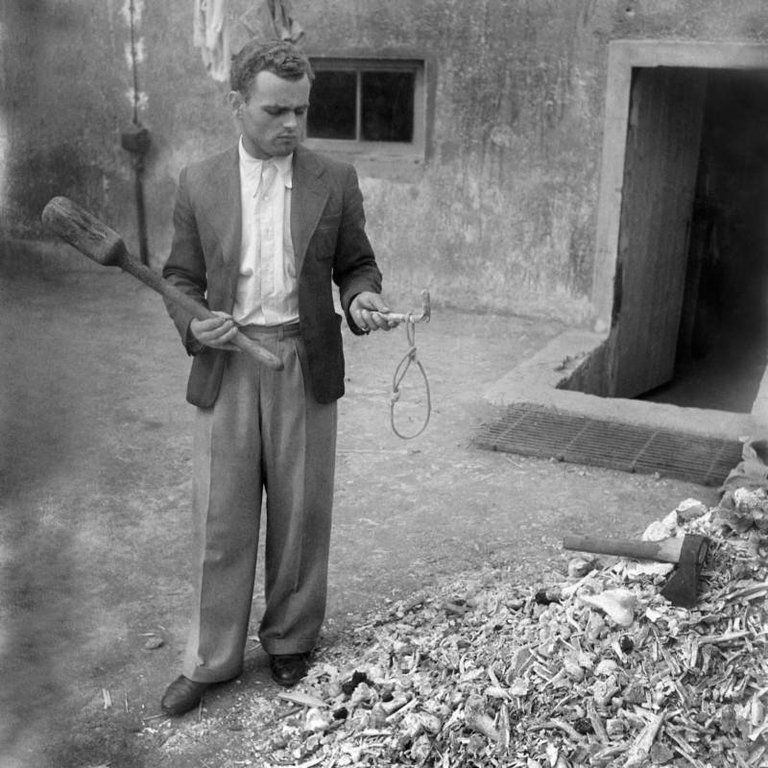 A man holds a noose used for hanging prisoners at the Buchenwald concentration camp following its liberation by U.S. forces in April 1945..jpg