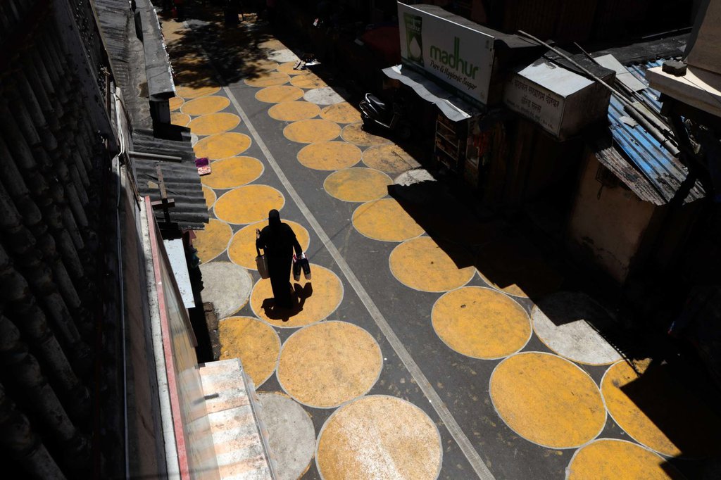 A woman walks along a road painted with circles to help people maintain social distancing in Mumbai, India, on June 29.Rajanish Kakade-AP.jpg