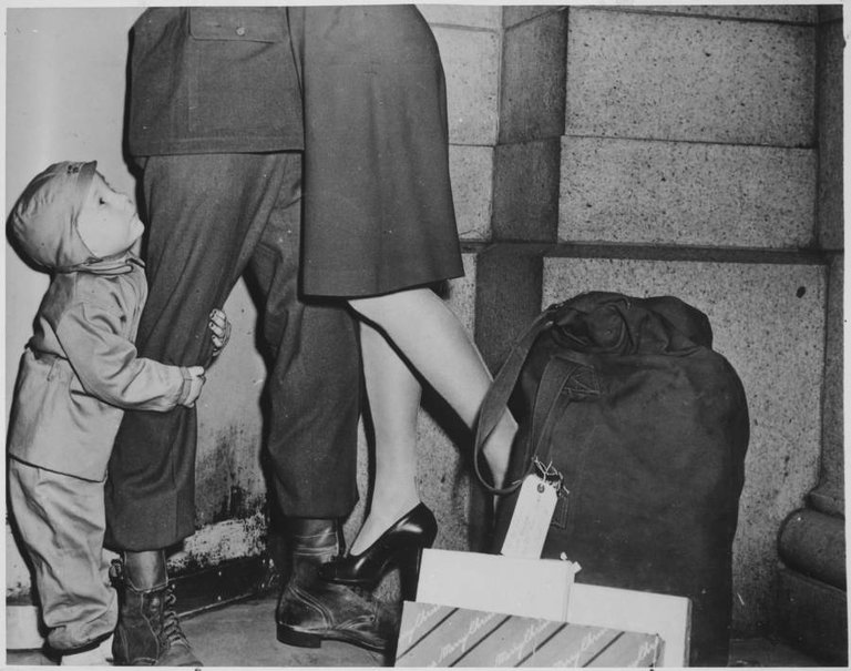 A young boy greets his father, a soldier allowed to return home for Christmas, 1944..jpg