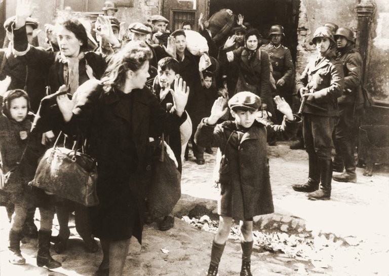 An unidentified boy raises his arms as German soldiers capture Polish Jews during the Warsaw ghetto uprising sometime between April 19 and May 16, 1943..jpg