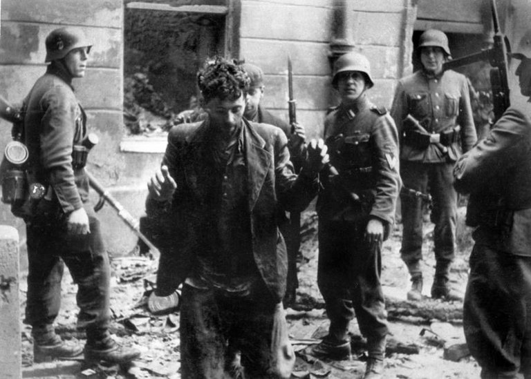 German soldiers arrest a Jewish man in Warsaw, Poland following the ghetto uprising that had recently occurred there, April 1943..jpg