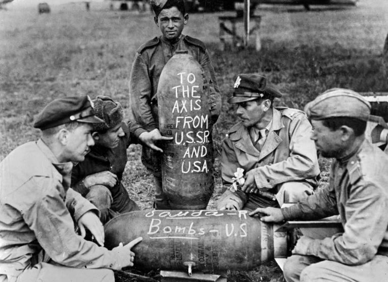 Soviet and American airmen pose with the bombs on which they'd written messages for the Nazis at a Russian air base on June 2, 1944..jpg