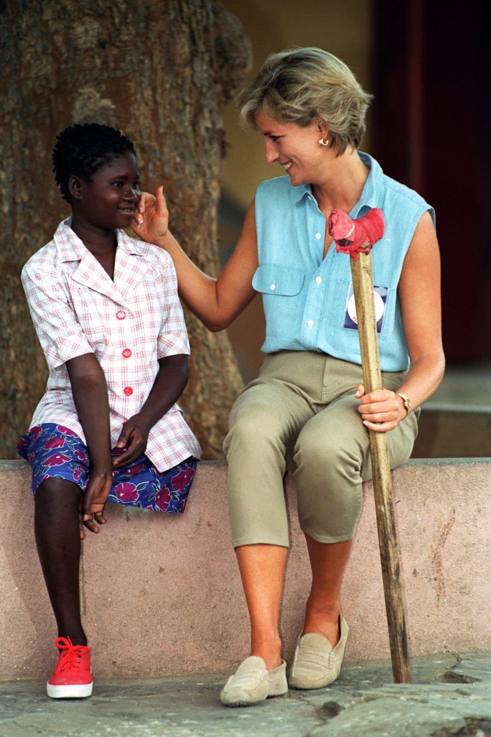 Talking to a child while visiting an orthopedic workshop In Luanda, Africa 1997.jpg